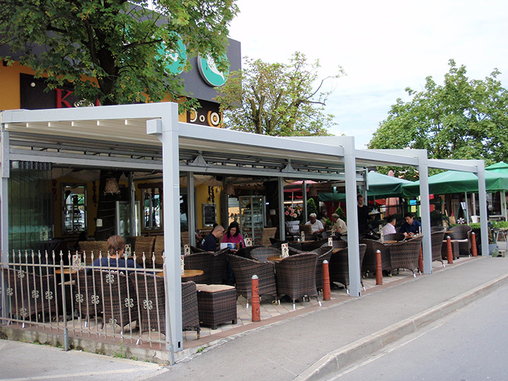 white pergola with people sitting down at bar and restaurant under it